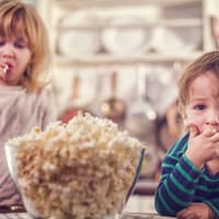 Zwei kleine Kinder essen Popcorn 