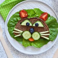 Ein Katzengesicht aus Brot, Obst und Gemüse