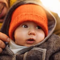 Ein Vater hält sein Baby im Arm. 