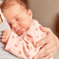 Neugeborenes Baby kuschelt auf dem Arm seiner Mutter. 