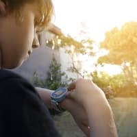 Junge ruft seine Mutter auf seiner Smartwatch an. 