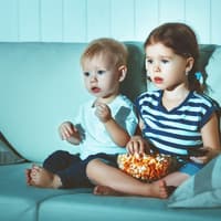 Zwei Kinder sitzen auf dem Sofa