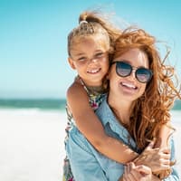 Eine Wassermann-Mutter mit ihrer Tochter am Strand.