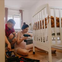 Schwangere bereitet Babybett vor