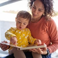 Mama und Kleinkind schauen sich ein Buch an