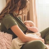 Eine Mama stillt ihr Baby.