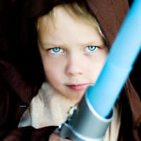 Ein Junge ist als Jedi-Ritter verkleidet.