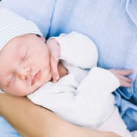 Mutter mit ihrem neugeborenen Baby auf dem Arm.
