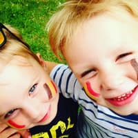 Zwei belgische Kinder mit aufgemalter Flagge auf den Wangen