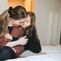 Mutter und Tochter nehmen sich nach einem Streit in den Arm.