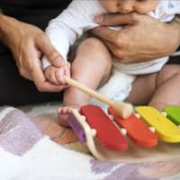 Vater übt mit seinem Baby Xylophon-Spielen