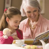 Oma schaut mit Enkelin ein Buch an.