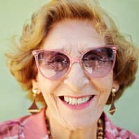 Lachende alte Frau mit rosa Sonnenbrille.