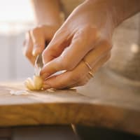 Eine Frau schneidet Knoblauch in Scheiben.