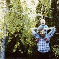 Junger Vater in den achtziger Jahren mit seinem Sohn.