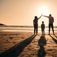 Familie am Strand im Sonnenuntergang.