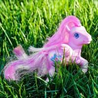 Ein pinkes Pferd, das zu den "My littly Pony" von früher gehört, steht auf dem Rasen.