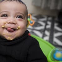 Kleiner Baby-Junge freut sich über seinen Pastinaken-Brei