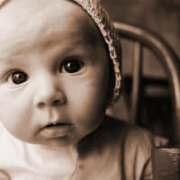 Schwarzweiß-Foto von Baby mit Mützchen.