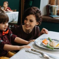 Kleiner Junge am Tisch im Restaurant mit Mutter.