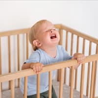 Ein Kleinkind wird im Kinderbett wütend