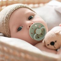 Baby liegt im Bettchen.