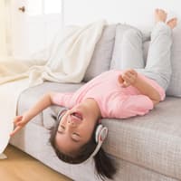 4-Jährige hört Musik mit Kopfhörern.