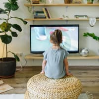 Ein kleines Mädchen guckt Fernsehen. 