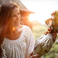 Eine Frau bekommt ein Ostergeschenk überreicht und freut sich.