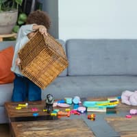 Kind schüttet eine Spielzeugkiste aus.