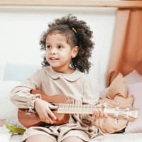 Kleines Mädchen spielt Ukulele.