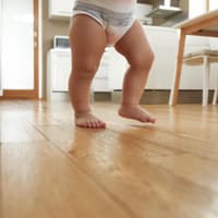 Babybeine beim Laufen in der Küche.