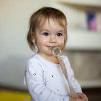 Ein kleines Mädchen mit Schnuller im Mund