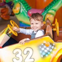 Ein kleiner Junge im Auto im Freizeitpark.