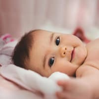 Baby lächelt in die Kamera.