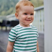 Ein kleiner Junge schaut verschmitzt.