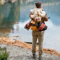 Vater lässt das Baby auf seinem Rücken hängen.