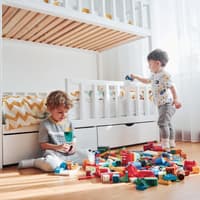 Zwei Jungs spielen neben ihrem Hochbett.
