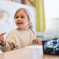 Ein kleines Mädchen mit einem Stift in der Hand. 