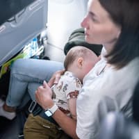 Mutter mit Baby im Flugzeug.
