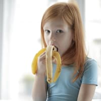 Kind isst Banane.