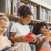 Kinder lesen in der Bibliothek.