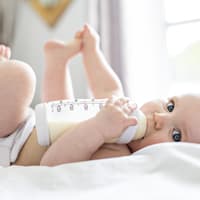 Baby trinkt aus Fläschchen.