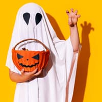 Kind zu Halloween als Gespenst verkleidet.