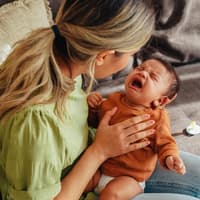 Mama versucht, ihr Neugeborenes zu beruhigen.