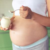 Schwangere Frau isst Panna Cotta.