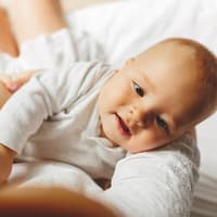 Baby liegt im Arm der Mutter.