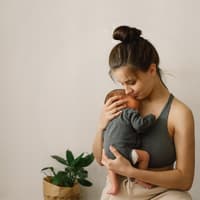 Mutter trägt Baby im Arm.