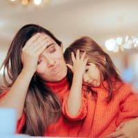 Mutter und Tochter halten sich die Hand an die Stirn.