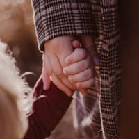 Mutter und Kind halten Händchen.